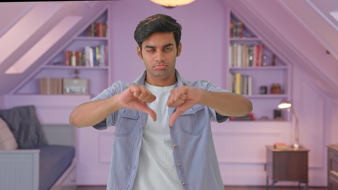 실망 한 인도인 이 엄지 손가락 을 내려 보이고 있다