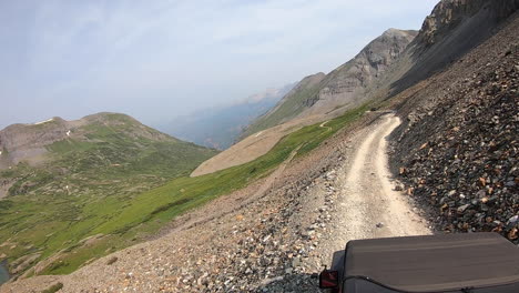 rooftop view of driving on black bear pass trail cut into a steep and rock mountainside high above mineral creek basin near telluride colorado