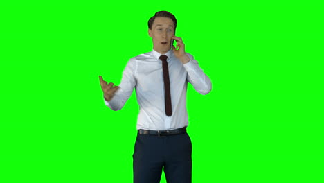 Smiling-businessman-having-phone-call-on-green-screen-