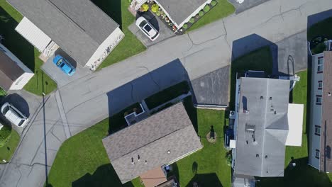 an aerial down looking view of a well kept mobile, manufactured, prefab home park of single wide and double wide houses on a sunny day