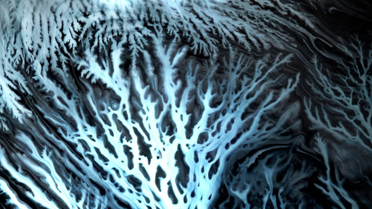 Abstract macro shot of swirling ink creating intricate, branching patterns on surface