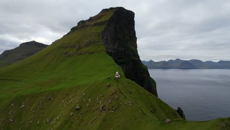 aerial static shot of a dramatic edge of a cliff behind kallur lighthouse