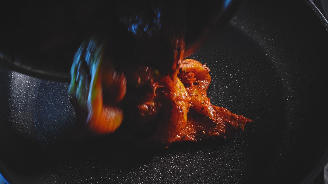 poner pechuga de pollo sazonada en una sartén para cocinar