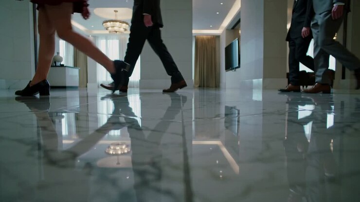 Entering from sides, team crossing marble lobby floor, wearing suits, skirt, heading for meeting
