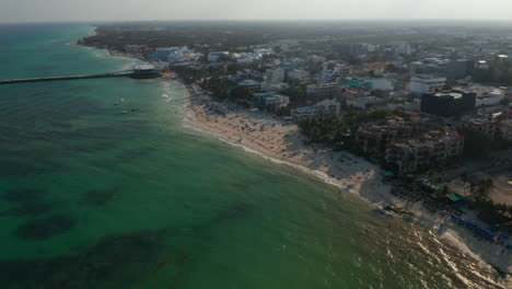 Atemberaubende-Luftige-Strandlandschaft-Mit-Pier,-Sandstrand-Und-Hotels-An-Der-Küstenlinie-Des-Karibischen-Meeres.-Schuss-Herausziehen