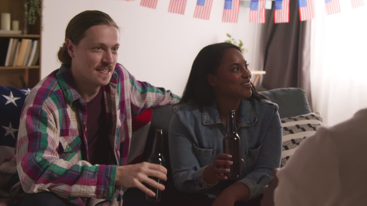 집에서 미니어처 미국 별과 줄무 발을 가진 컵케이크를 제공하는 여성은 7월 4일 독립기념일을 축하하는 파티에서 친구들에게