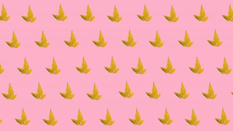 Digital-animation-of-multiple-autumn-maple-leaves-icons-in-seamless-pattern-on-pink-background