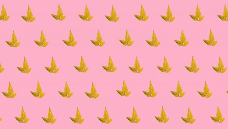 animación digital de varios iconos de hojas de arce de otoño en un patrón sin costuras sobre fondo rosa