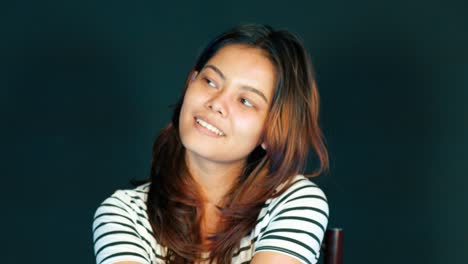 innocent young woman smiling and delightfully daydreaming about something pleasing