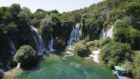 picturesque waterfall paradise with swimming lake in europe, aerial orbit