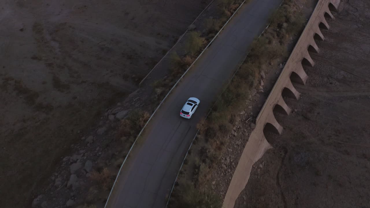 Car driving over dam bridge, follow shot