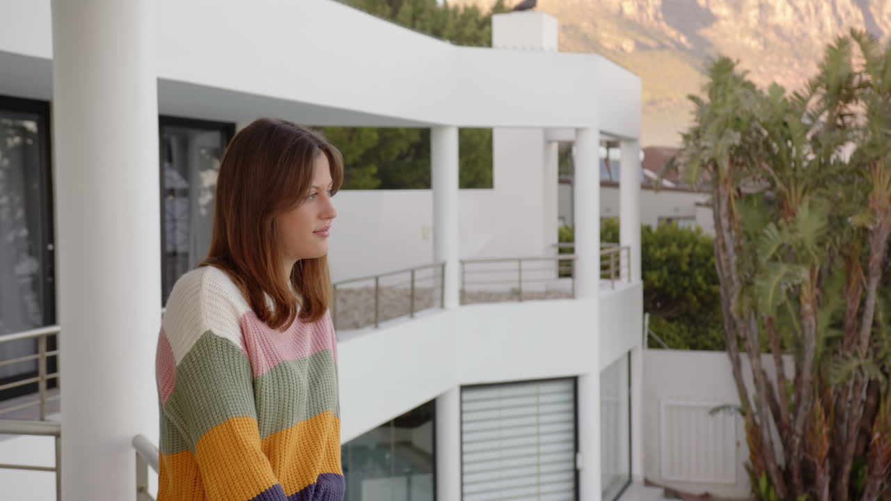 Relaxing on balcony, woman in colorful sweater enjoying peaceful home retreat, copy space