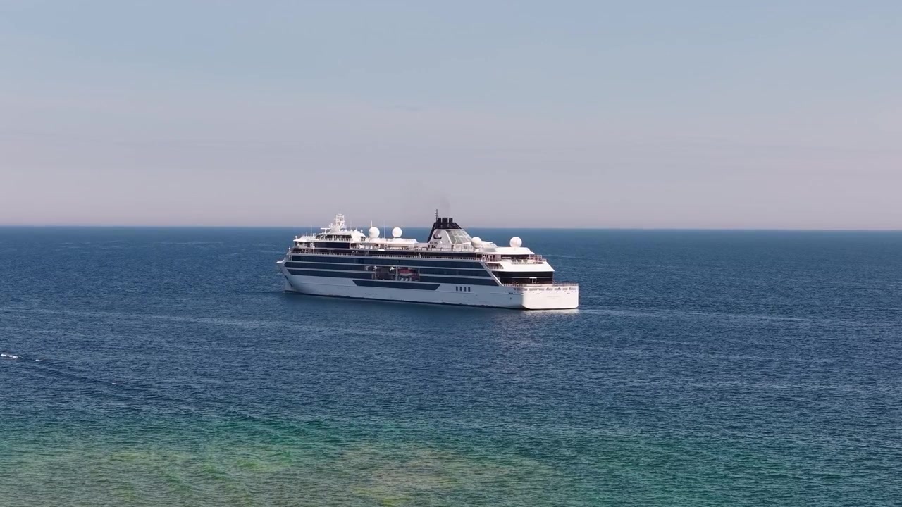 Luftfoto af en passagerfærge, der sejler over blåt vand nær Mackinac Island i det nordlige Michigan.