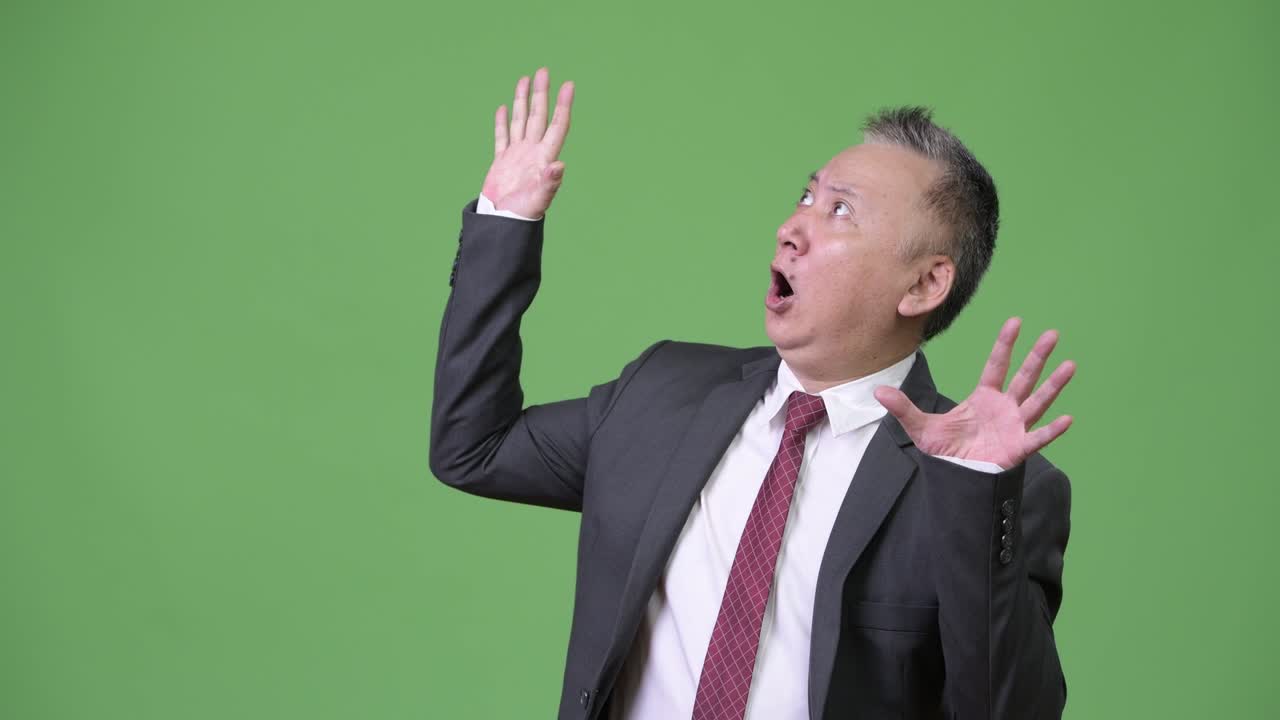 성숙한 일본인 사업가, 쳐다보면서 충격과 놀라움을 느다.