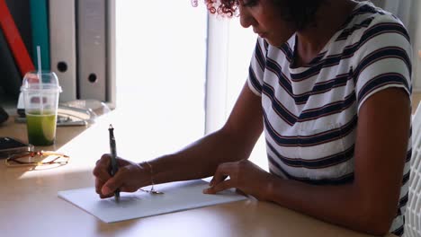 Female-executive-writing-on-paper-at-her-desk-4k