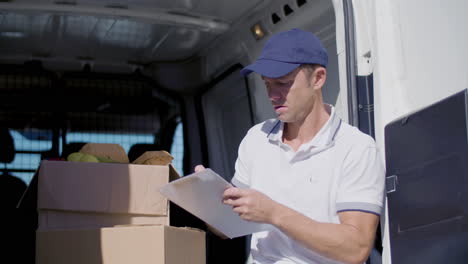 concentrated delivery man sitting in van and counting goods