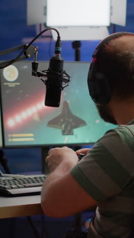 gamer playing video game on pc with headphone and microphone setup