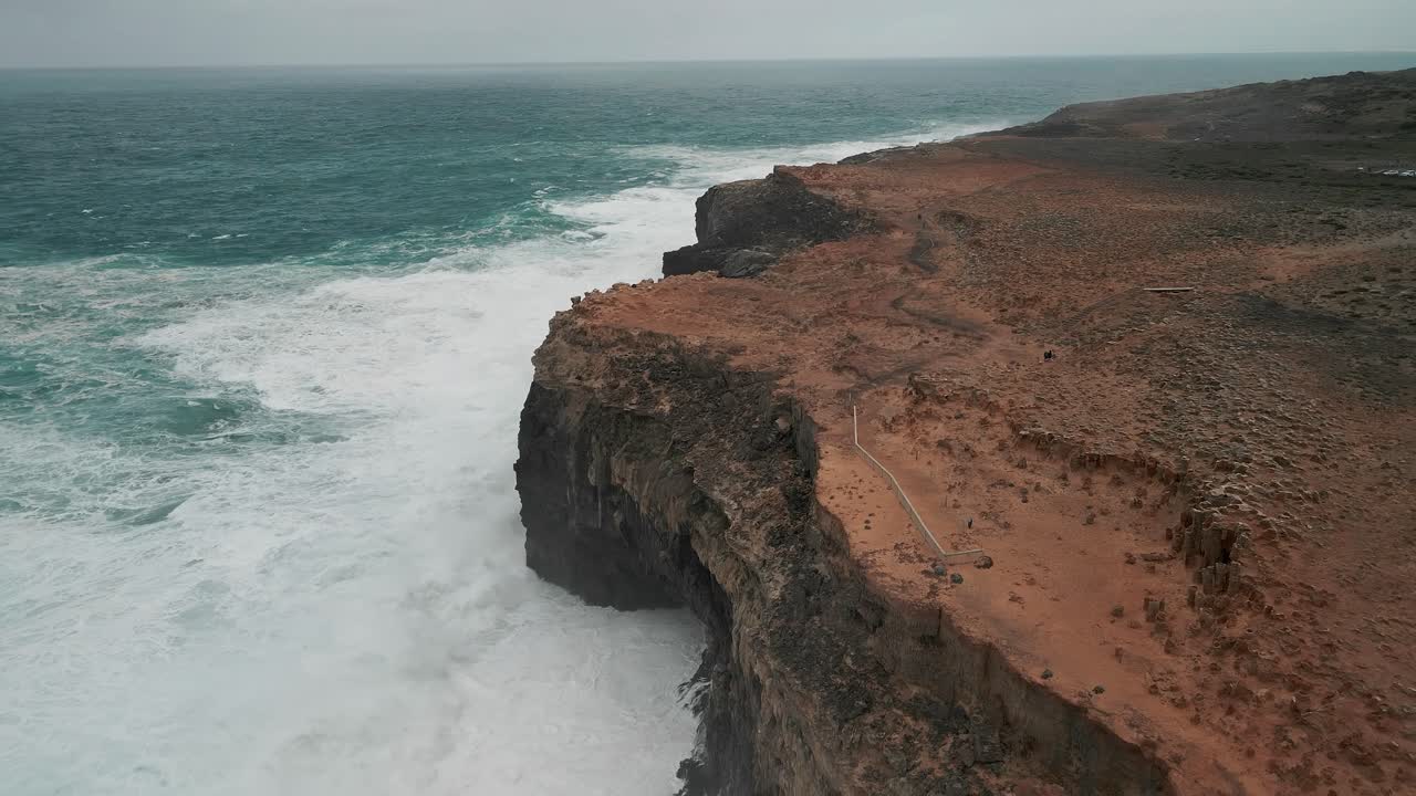 Drone view of ocean water hitting high grounds of Cape Bridgewater, Australlia