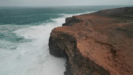 Drohnenansicht-Des-Meerwassers,-Das-Auf-Die-Anhöhen-Von-Cape-Bridgewater,-Australien-Trifft