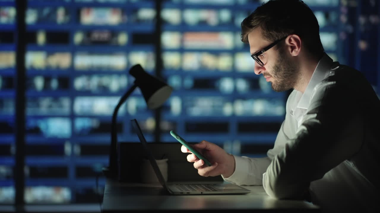 Man sms texting using app on smart phone at night. He's influential and well connected throughout this city