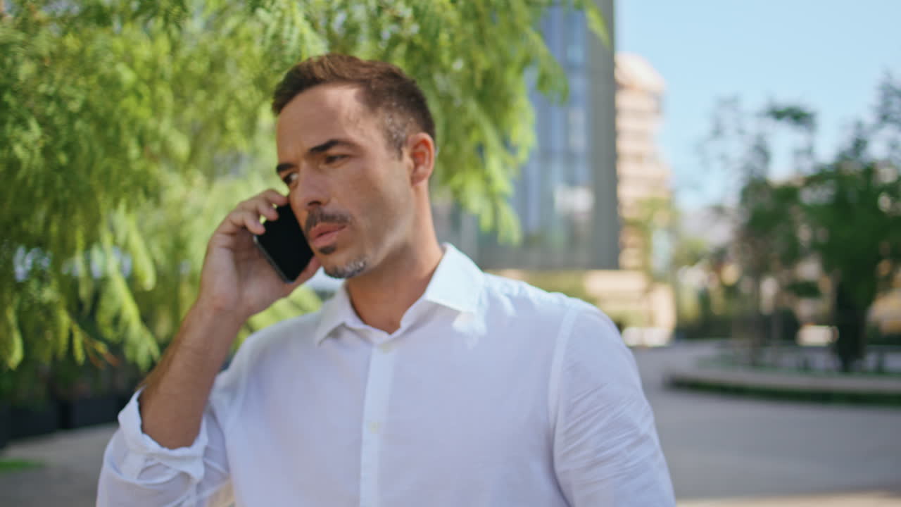Confident director calling mobile phone at business building background closeup