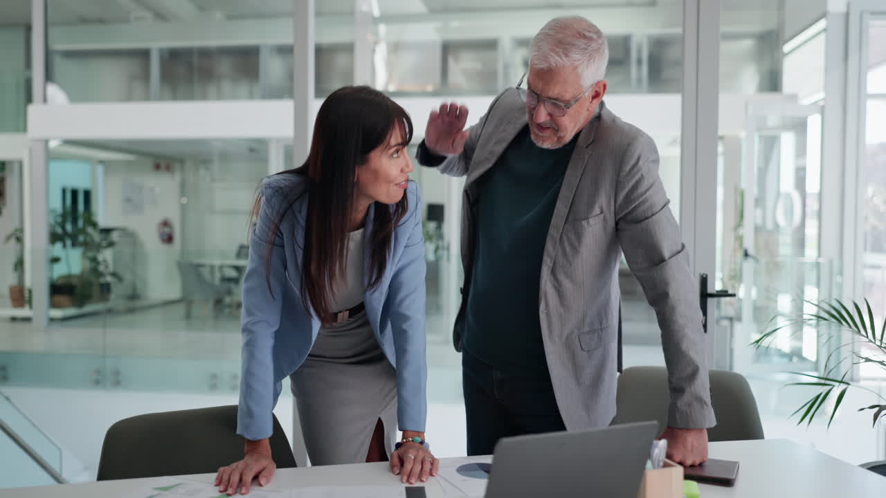 Colleghi di lavoro che si danno il cinque dopo una collaborazione di successo in un ufficio moderno