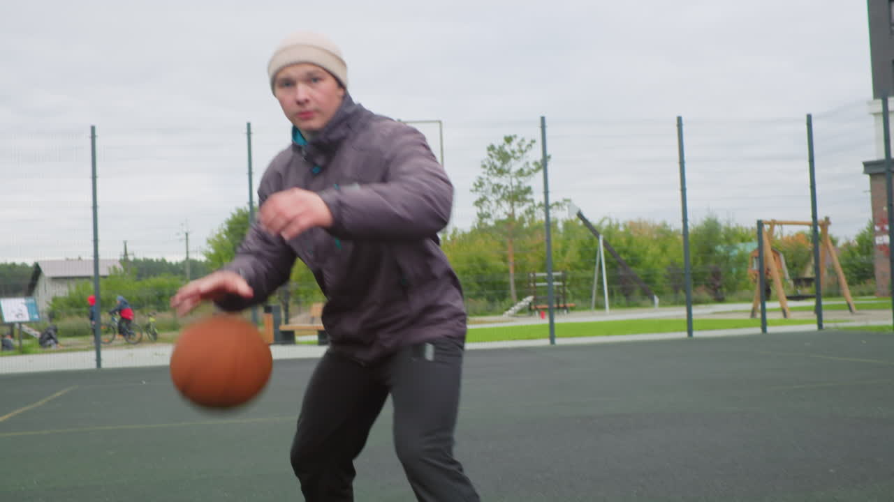 Park court white man driving baseline in quick drill, rapid crossover and low follow, ball rising into cloudy sky toward backboard and rim, close ups of sneakers and net, energetic solo training