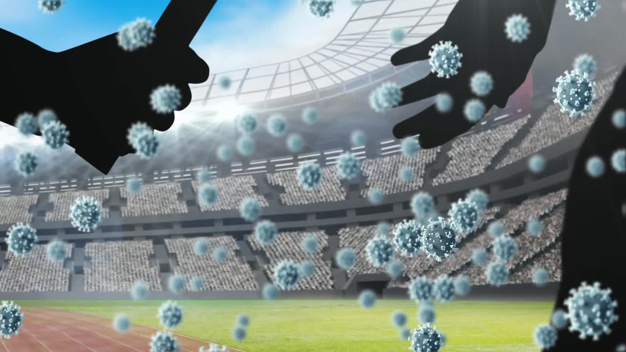 코로나19 세포가 스포츠 경기장을 향해 지 ⁇ 이를 전달하는 손의 실루 ⁇ 에 대해 떠다니고 있습니다.
