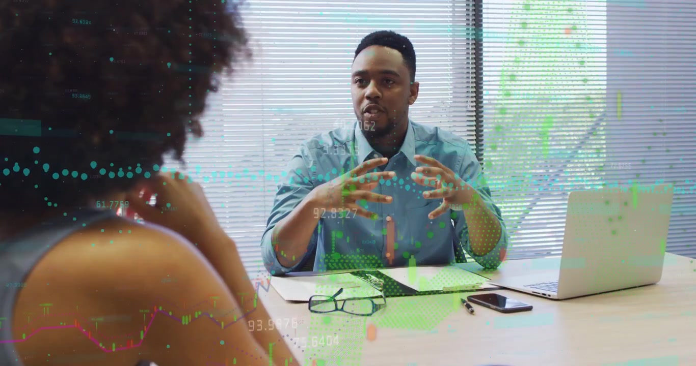 Man starting finance meeting, gesturing at desk while charts scrolling over laptop, explaining data