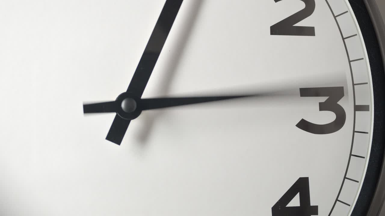 Primo piano del quadrante bianco dell'orologio in time-lapse su parete bianca.