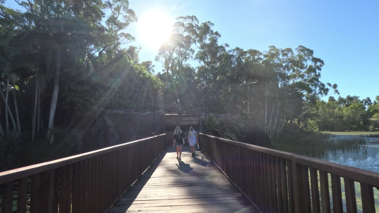 visitantes caminando por un puente en el zoológico de australia