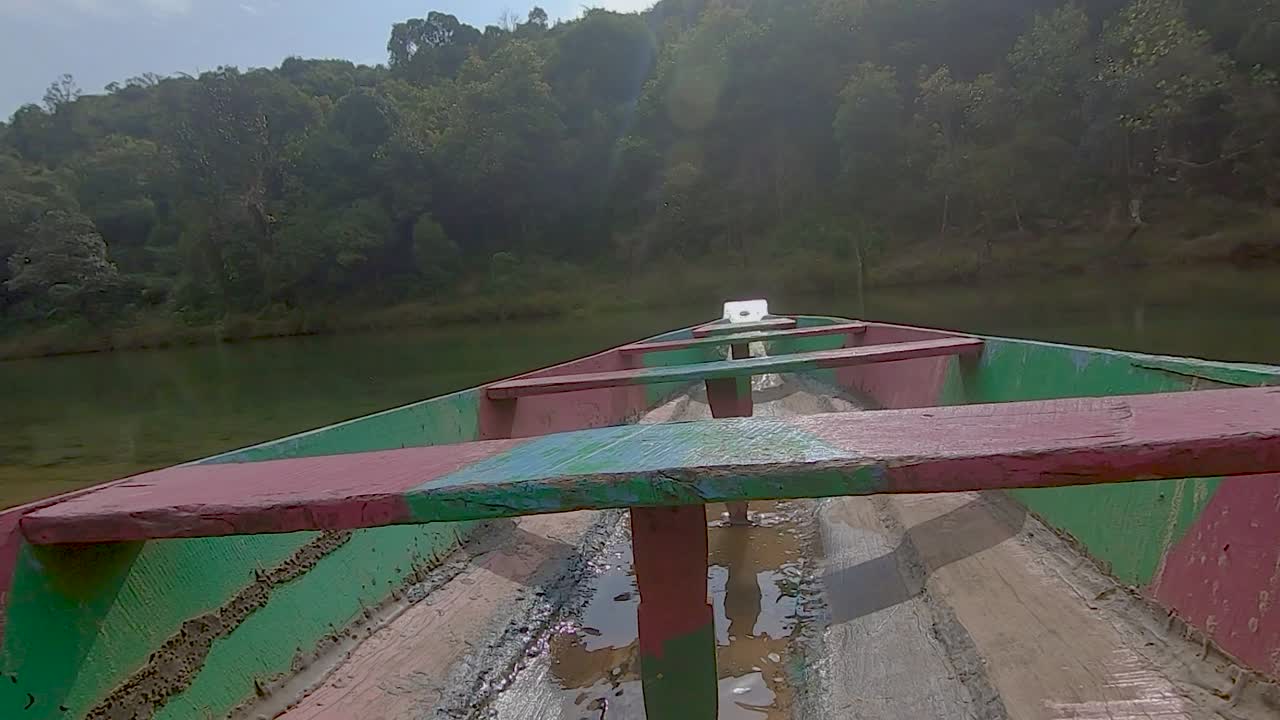 barco de madera tradicional aislado en la orilla del río de día desde un ángulo plano