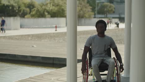 active young african american man using wheelchair in park