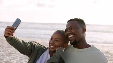 happy black couple taking selfie at the beach