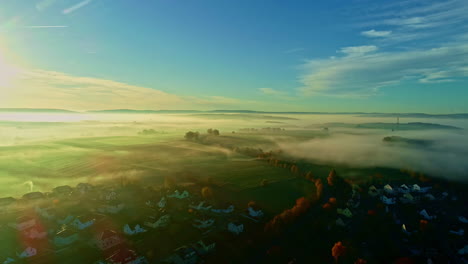 foggy clouds scattered over countryside village at sunrise