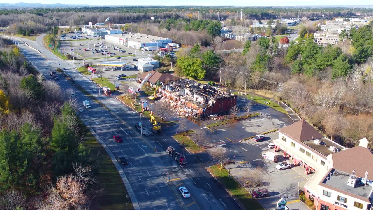 un drone se acerca y muestra carreteras, una intersección y un edificio devastado por el fuego que los bomberos están tratando de apagar, ubicado en toronto, canadá.