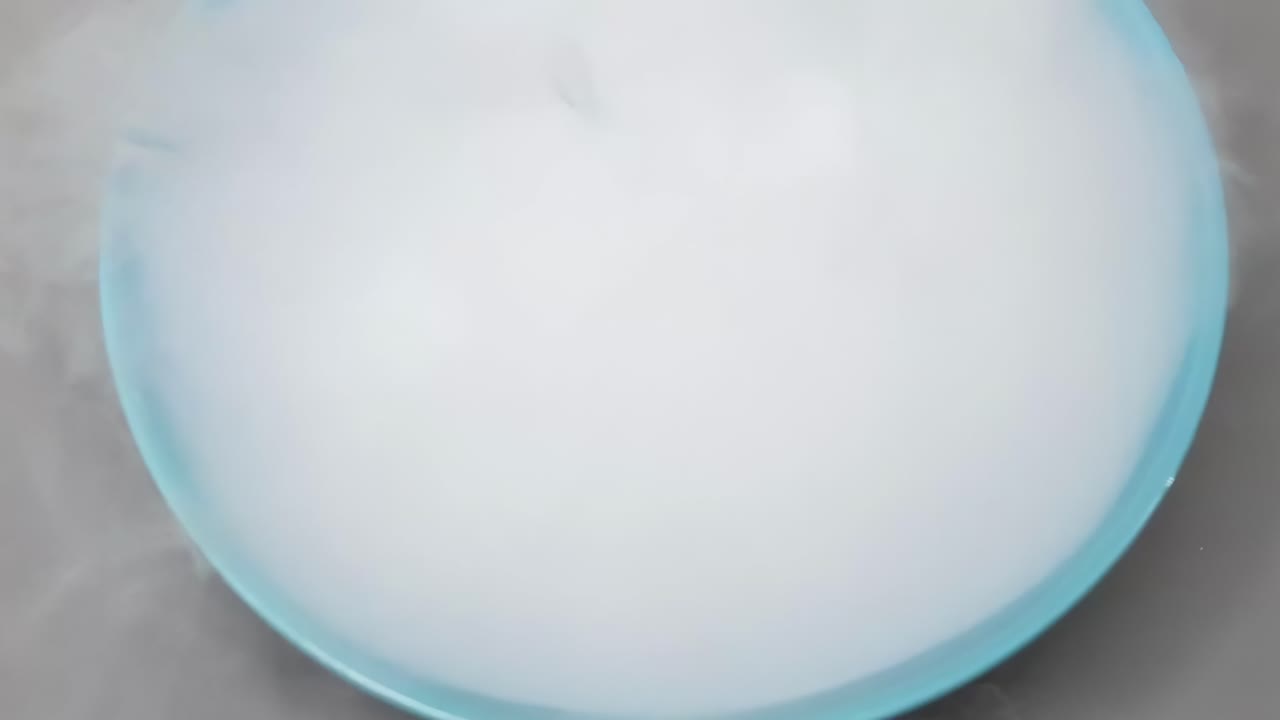 Watch dry ice sublimate in a blue bowl, creating dense fog and vapor.