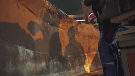 construction workers restoring historical stone structure at night