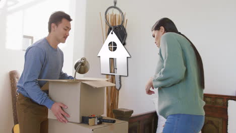 animation of silver house key and key fob over happy diverse couple moving in to new home