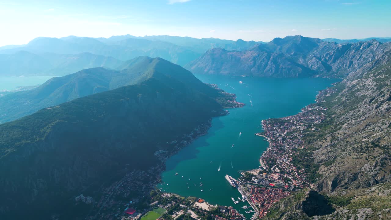 Spectacular aerial perspective of Kotor Golf. View of Kotor city sourrounded by mountains. Large criuse ship docked. Famous and luxury travel destination in Montenegro. Foggy morning