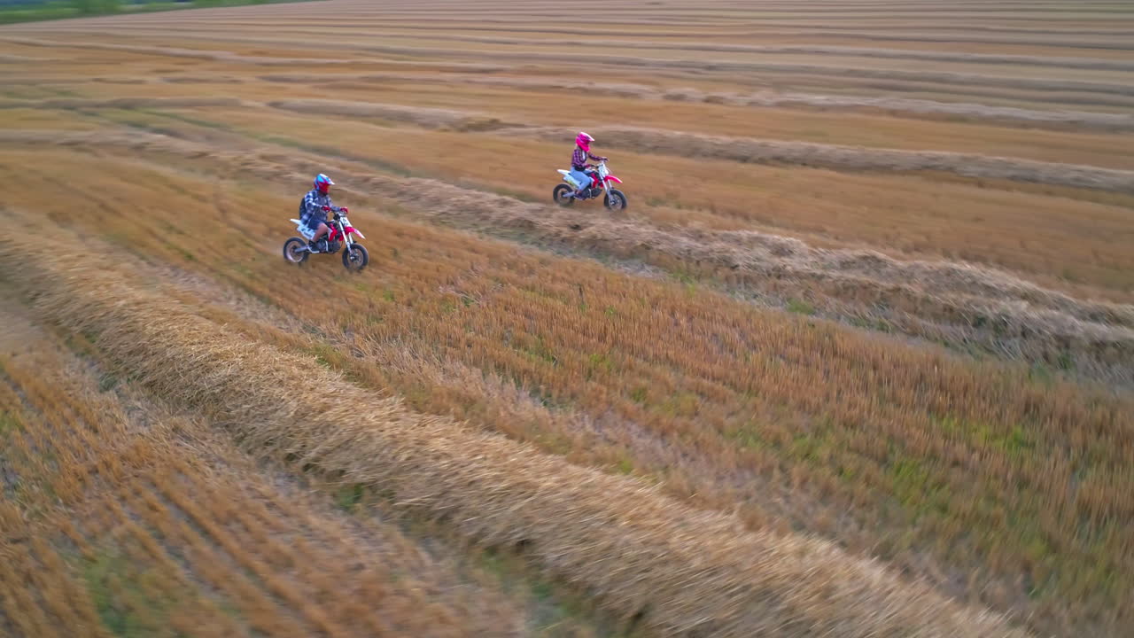 Kids Riding Motorbikes in a Hay Field
