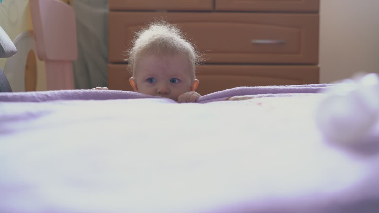 playful boy plays with plastic tube of medical tool at bed