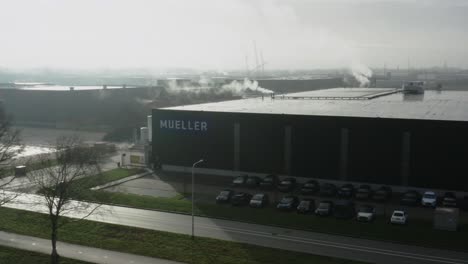 Aerial-shot-of-a-large-factory-building-in-the-morning-fog-in-the-Netherlands