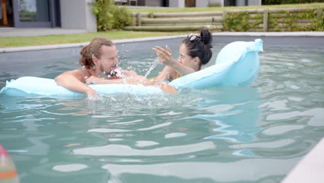 a young caucasian couple enjoys time in a pool, copy space