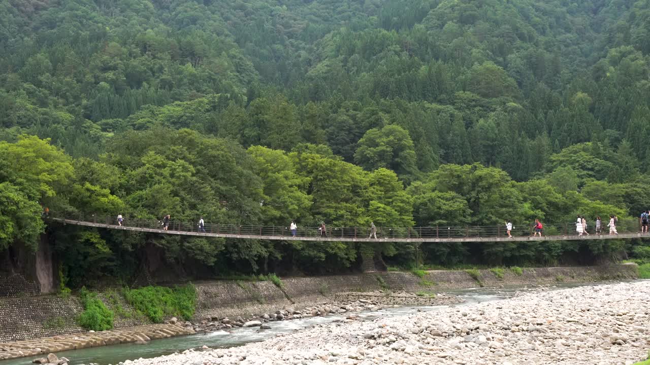Tourist walk through Shirakawago Kanazawa Bridge in sideview, Nagoya, Japan.