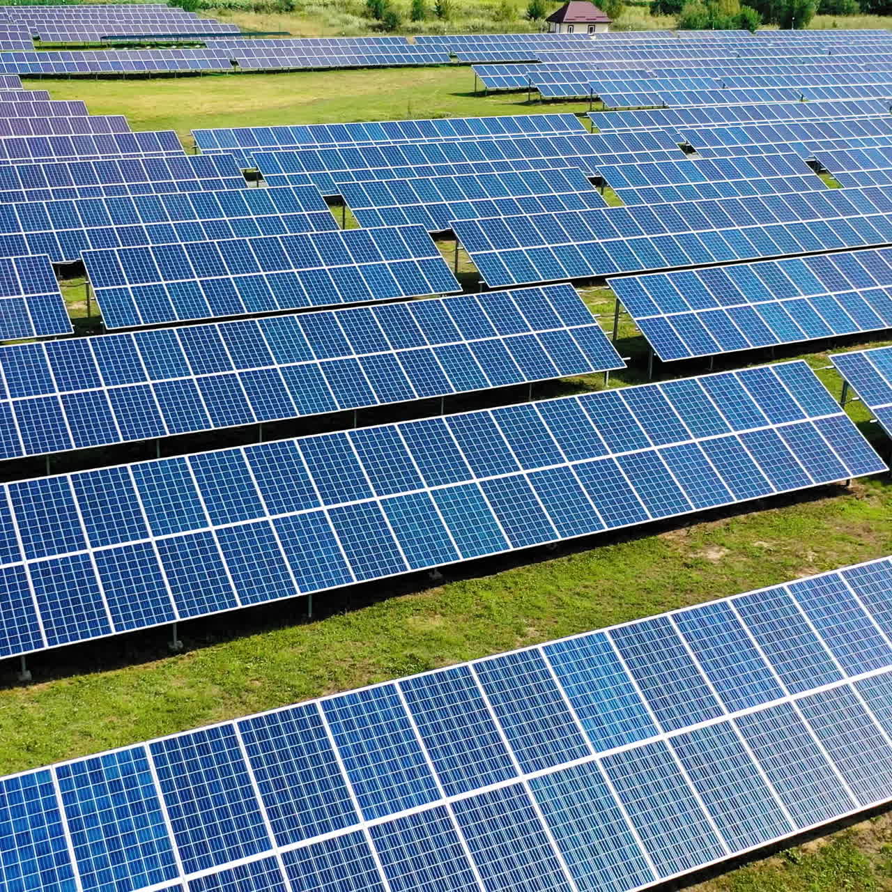 Rows of solar panels. Flight over photovoltaic power plant on the field. Renewable solar energy farm in summer.