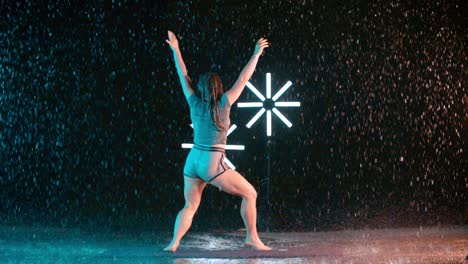 female caucasian dancer performing sensual contemporary dance moves, rain effect