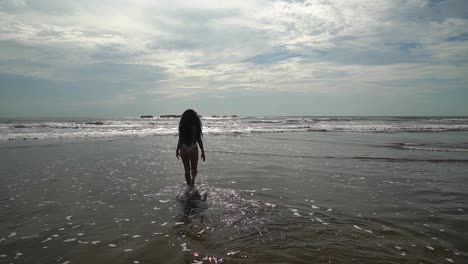 beautiful lady walking in the ocean while on holiday in costa rica