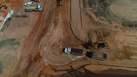 Drone-above-Earth-Mover-filling-dump-truck-with-dirt-on-a-construction-site