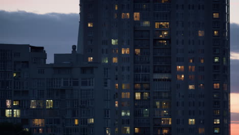 evening block of flats drone shot. multistoried buildings lights in windows.